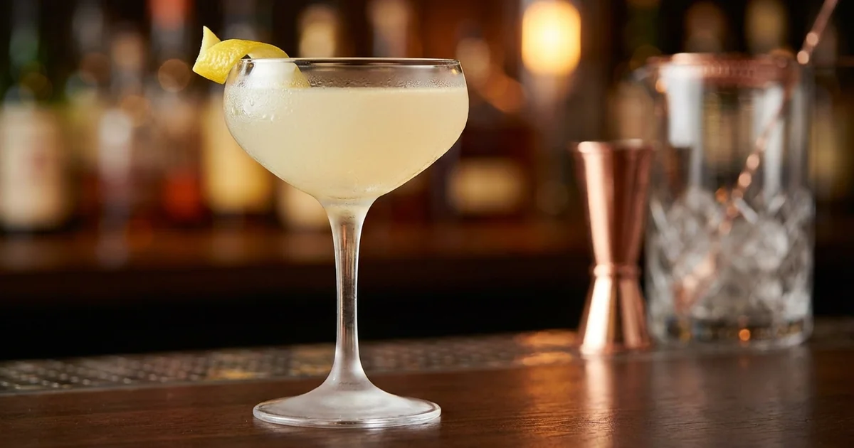 Professional photograph of a Bee's Knees cocktail with garnish in elegant bar setting